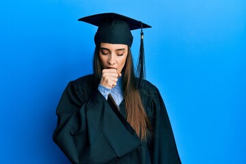 Beautiful brunette young woman wearing graduation cap and ceremony robe feeling unwell and coughing as symptom for cold or bronchitis. health care concept.