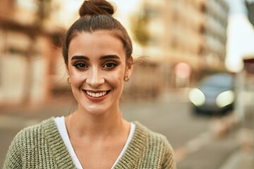 Beautiful brunette woman smiling happy and confident outdoors at the city on a sunny day of autumn