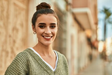 Beautiful brunette woman smiling happy and confident outdoors at the city on a sunny day of autumn