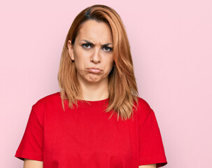 Hispanic young woman wearing casual red t shirt depressed and worry for distress, crying angry and afraid. sad expression.