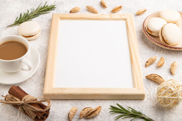 White wooden frame mockup with cup of coffee, almonds and macaroons on gray concrete background. side view