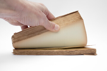 Hand opening antique book on white background
