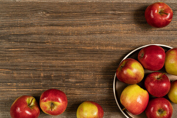 Fresh red apples in plate on the wooden table.Top view with copy space.