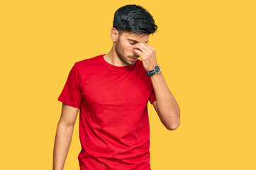 Young handsome man wearing casual red tshirt tired rubbing nose and eyes feeling fatigue and...