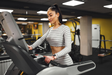 Young healthy woman cardio on a treadmill at the gym 