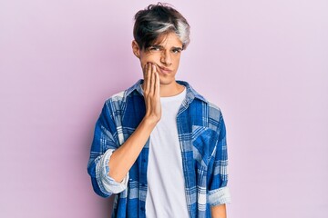 Young hispanic man wearing casual clothes touching mouth with hand with painful expression because of toothache or dental illness on teeth. dentist