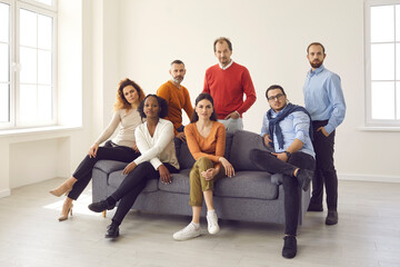 Diverse team of business partners and colleagues posing in new empty light office. Group portrait...