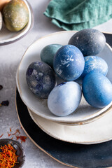 Easter eggs on a ceramic plate. Linen napkin. Gray background 