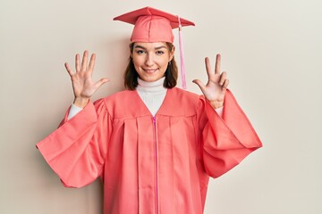 Young caucasian woman wearing graduation cap and ceremony robe showing and pointing up with fingers number eight while smiling confident and happy.