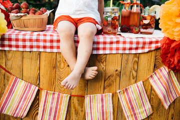 Lemonade Stand. Adorable little girl trying to sell lemonade. strawberry lemonade with ice and mint as summer refreshing drink in jars. Cold soft drinks with fruit. Child drinking lemonade in jar - obrazy, fototapety, plakaty