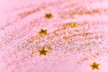 Golden glitter stars on a pink background. Universal festive background.