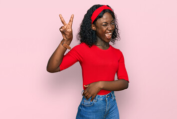 Beautiful african young woman wearing casual clothes smiling with happy face winking at the camera...