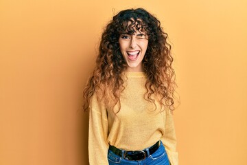 Young hispanic girl wearing casual clothes winking looking at the camera with sexy expression,...
