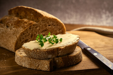 sliced toast bread with butter on wooden cutting board with knife