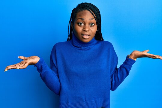 Young african american woman wearing casual clothes clueless and confused with open arms, no idea and doubtful face.