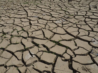 Deep cracks in the land as a symbol of hot climate and drought. Desert and cracked ground. Uneven,...
