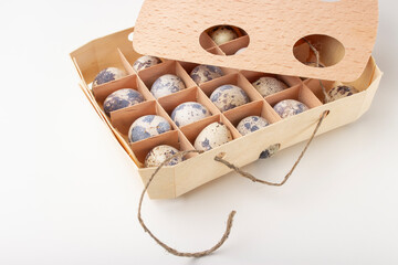 Quail organic eggs in a wooden box with a string 