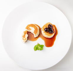 Cheesecakes on a plate with jam and berries on top