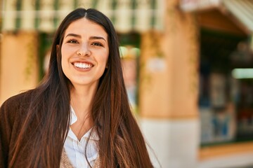 Young hispanic woman smiling happy standing at the city.