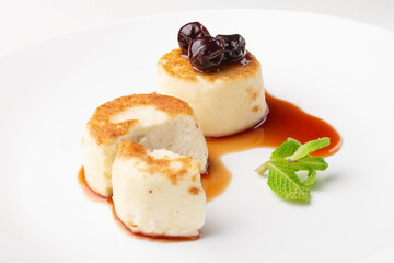 Cheesecakes on a plate with jam and berries on top