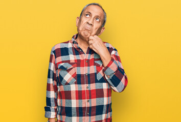 Senior hispanic man wearing casual clothes serious face thinking about question with hand on chin, thoughtful about confusing idea