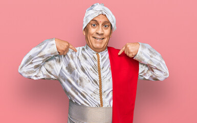 Senior hispanic man wearing tradition sherwani saree clothes looking confident with smile on face, pointing oneself with fingers proud and happy.