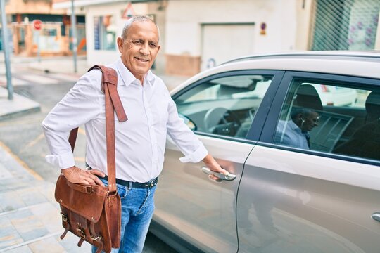 Senior man smiling happy opening car at the city.