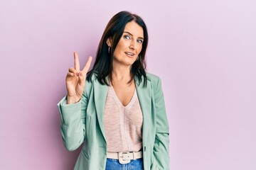 Middle age brunette woman wearing casual clothes smiling looking to the camera showing fingers...