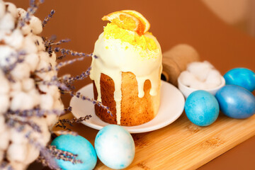 Spring composition with Easter cake and colored eggs on brown background. Beautiful card for Easter. Easter famyly dinner.