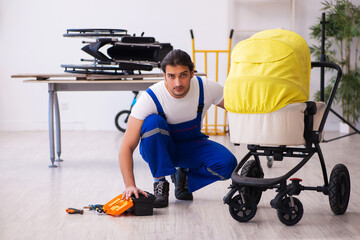 Young male repairer repairing perambulator indoors