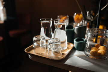 Four glass cups on the bar counter with serving accessories.