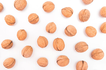 Heap of whole walnuts in the shell isolated on white background