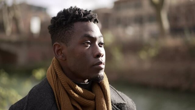 Young black man walking outside in nature during winter season