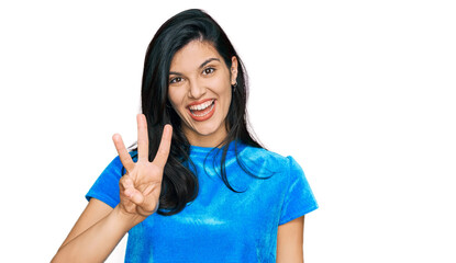 Young hispanic woman wearing casual clothes showing and pointing up with fingers number three while smiling confident and happy.