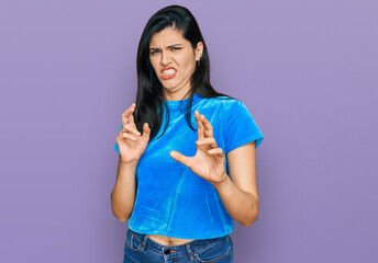 Young hispanic woman wearing casual clothes disgusted expression, displeased and fearful doing...