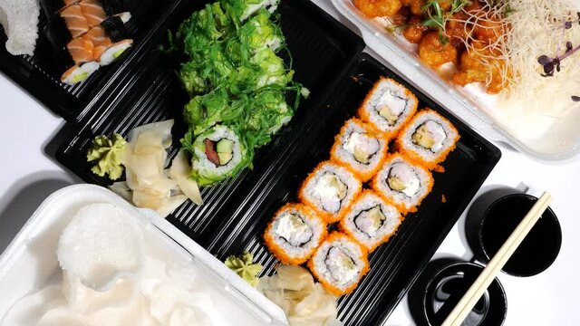 Assorted Asian, Chinese, Thai and Vietnamese food, sushi set, rolls, noodles, seafood, vegetables, shrimps chips take away container boxes, package lunch to go. Top view flat lay. Healthy balanced die