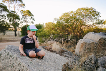 Little boy sitting on rocks in beautiful Australian bush setting