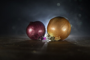 Vegetable concept. Onions in dark on wooden table. Selective focus