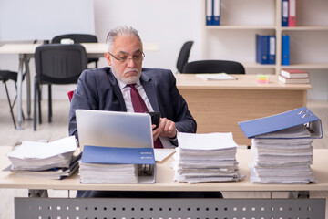 Fototapeta na wymiar Aged male employee and too much work at workplace