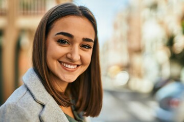 Young hispanic girl smiling happy standing at the city.