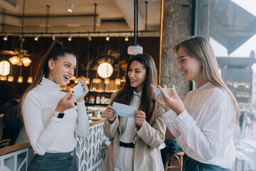 Caucasian women taking off a medical mask in a cafe