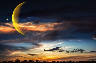 silhouette of the city against the backdrop of the sky and crescent © yaalan