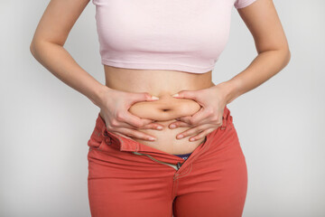 Woman holding on to fat on her belly. Diet, overweight, obesity concept