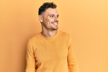 Young hispanic man wearing casual clothes looking to side, relax profile pose with natural face and confident smile.