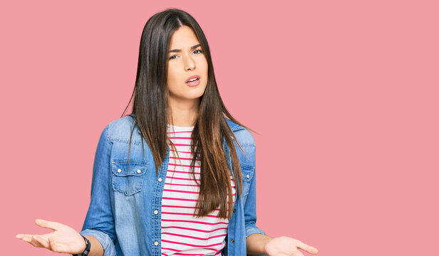 Young brunette woman wearing casual clothes clueless and confused with open arms, no idea concept.