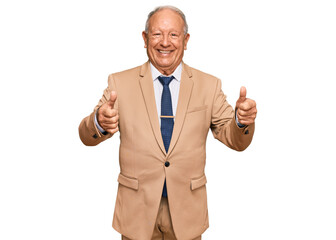 Senior caucasian man wearing business suit and tie approving doing positive gesture with hand, thumbs up smiling and happy for success. winner gesture.