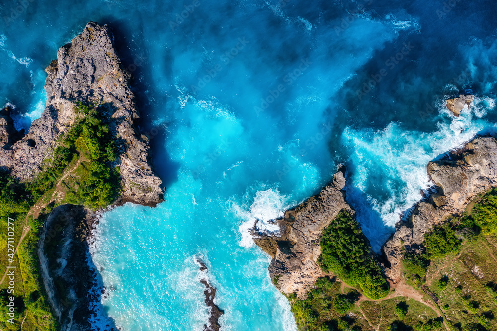 Wall mural waves and rocks as a background from top view. blue water background from top view. summer seascape 