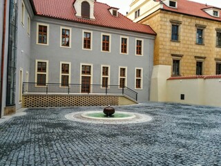 Old town street. Small round fountain in Prague. Czech Republic.