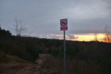 "sign ban bathing" at descend to the lake, on a background of the sky