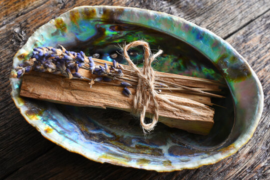A top view image of smudge sticks with dried lavender in an abalone shell. 